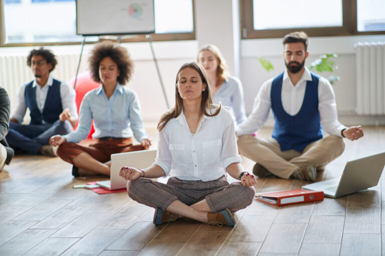 Businesswoman meditating at work.group of business coworkers meditating together at work.